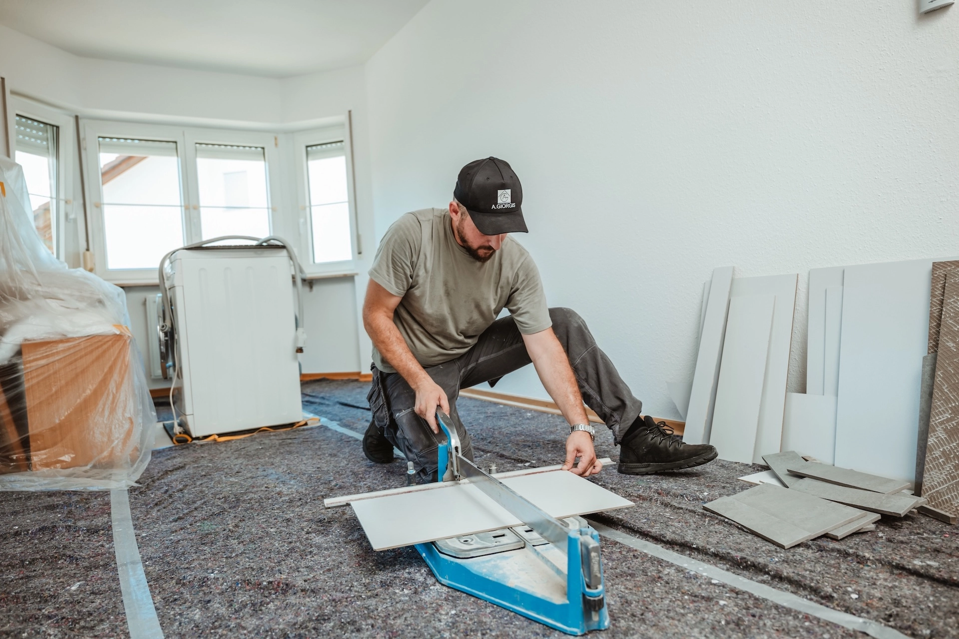 Thomas Nikollas von Alexandros Giorgis bei einer Badsanierung in Freiburg am Fliesen Schneiden