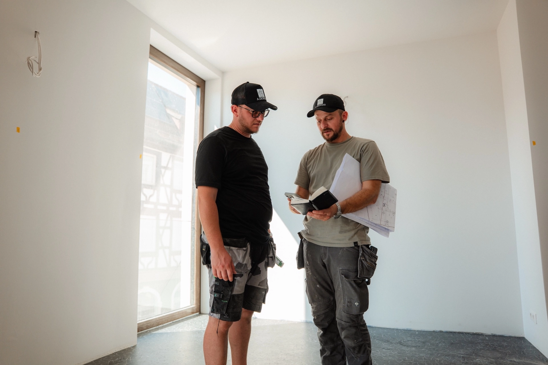 Thomas und Konstantinos Nikollas von Alexandros Giorgis besprechen eine Baustelle einer Altbausanierung in Freiburg