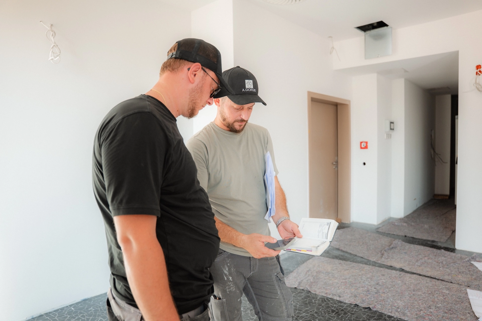 Thomas und Konstantinos Nikollas von Alexandros Giorgis besprechen eine Baustelle einer Altbausanierung in Freiburg