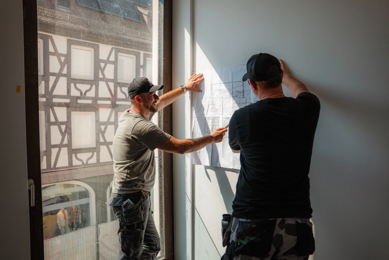 Thomas und Konstantinos Nikollas von Alexandros Giorgis besprechen die Pläne einer Altbausanierung in Freiburg