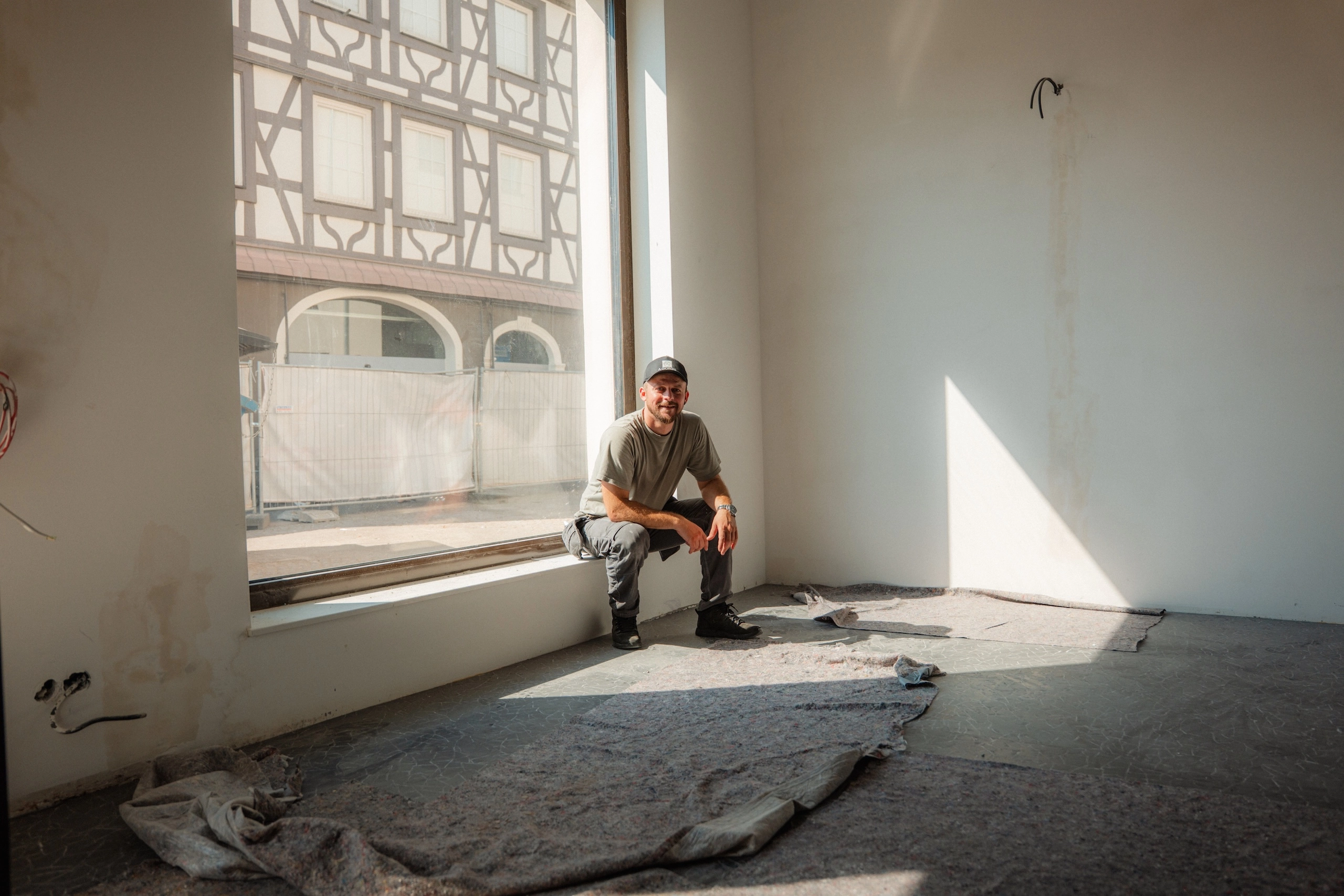 Thomas Nikollas von Alexandros Giorgis Innenausbau und Raumausstattung in Freiburg sitzt in einer Altbauwohnung in Sanierung